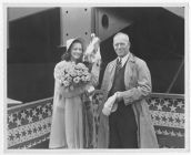 Woman holding flowers, and man holding his hat, aboard the towboat "Stanolind A"